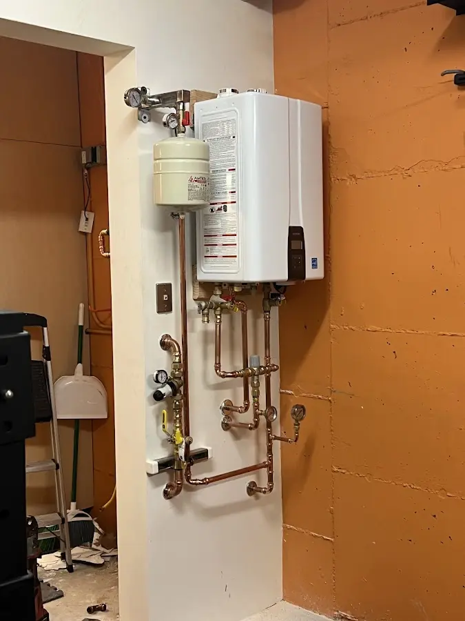 Plumbing technician inspecting water heater connections in League City